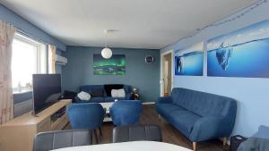 伊卢利萨特Ilulissat Apartment的客厅配有蓝色的椅子和桌子