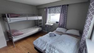 伊卢利萨特Ilulissat Apartment的一间卧室设有两张双层床和一扇窗户。