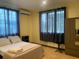 阿皮亚Samoa Business Apartments的一间卧室配有一张带蓝色窗帘的大床