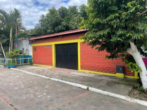 GarzónLa Casa de Mónyk de la P En la jagua Huila的一座黄色和红色的砖砌建筑,设有车库