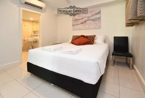 达尔文"NEWQUAY" Ideal Location & Views at PenthousePads的卧室配有一张白色大床和一张黑椅