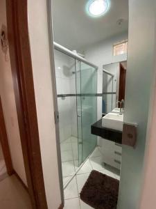 伊列乌斯Apartamento centro de Ilhéus - 2Suítes, 6 hóspedes的一间带玻璃淋浴和水槽的浴室