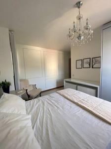 伊列乌斯Apartamento centro de Ilhéus - 2Suítes, 6 hóspedes的卧室配有一张白色大床和吊灯。