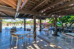 维雷亚Maui Kamaole的一个带桌椅的庭院和一个游泳池
