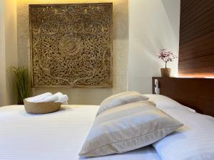 圣多明各Boutique Hotel Casa Grande的一张带两个枕头的床和一张墙上的照片