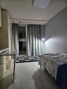 首尔Urban Space Sinnonhyeon的一间卧室配有一张床和一张玻璃桌
