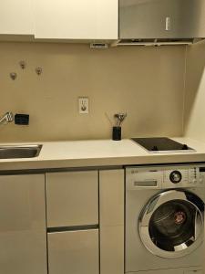 首尔Urban Space Sinnonhyeon的厨房配有洗衣机和柜台。