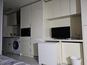 首尔Urban Space Sinnonhyeon的厨房配有白色橱柜、洗衣机和烘干机