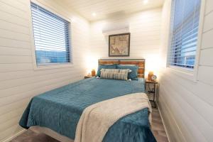 阿尔派恩New Southwest Shipping Container-In Alpine的一间卧室配有一张蓝色棉被和两个窗户。