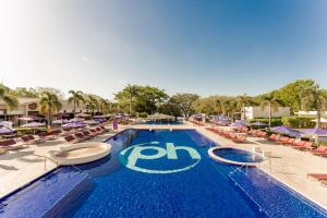 CulebraPlanet Hollywood Costa Rica, An Autograph Collection All-Inclusive Resort的一个带椅子和遮阳伞的大型游泳池