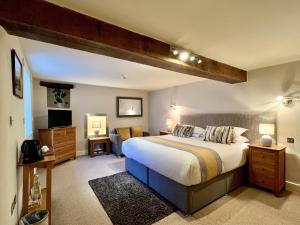 哈雷克Castle Cottage Inn的一间卧室配有一张大床和一张沙发
