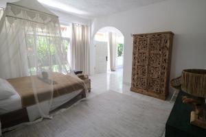 乌布Villa Kassi: 1 bed en-suite, large garden, pool.的一间卧室配有一张床和一扇木门