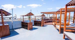 悉尼Mad Monkey Bayswater的一个带木凳和遮阳伞的屋顶露台