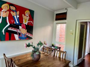 墨尔本Lovely Victorian Terrace - Entire home的餐桌,墙上挂着绘画