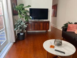 墨尔本Lovely Victorian Terrace - Entire home的客厅配有平面电视和桌子。