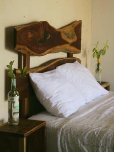 巴卡拉尔Tropic Bacalar的一张带木制床头板的床和一瓶葡萄酒