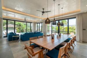 MungguCemagi Beachside Sultana: 5BR Luxury Villa Canggu的用餐室配有大型木桌和椅子