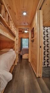 查塔努加Eden Cabin Forested Tiny Home On Lookout Mtn的小木屋内一间卧室配有两张双层床