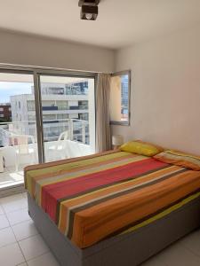 埃斯特角城Apto 3 dormitorios, Punta del Este parada 2的一间卧室设有一张床和一个大窗户