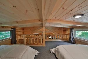 查塔努加Bryce Cabin Lookout Mtn Tiny Home W Swim Spa的小木屋内的卧室,配有两张床