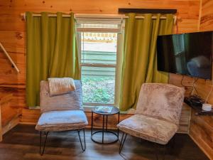 查塔努加Elise Cabin Forest Retreat 5 Mins To Downtown的窗户间设有两把椅子和一台电视机