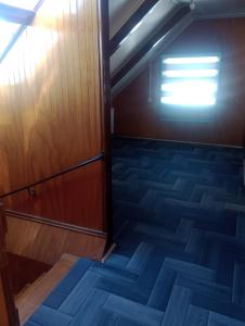 纳塔列斯港Isla yu backpacker的一间空房间,设有木门和楼梯