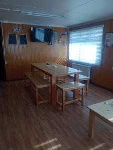 纳塔列斯港Isla yu backpacker的一间设有桌子、长凳和窗户的房间