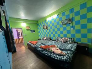 西姆拉The City Escape Farmstay的一间卧室配有床,蓝色和绿色
