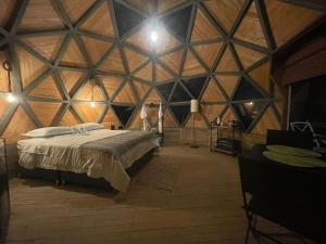 里奥内格罗Vitta Glamping的木制客房内的一间卧室配有一张大床