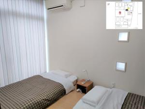 熊本Kumamoto - House - Vacation STAY 83489的一间卧室配有两张床,一个床头柜和一张床。