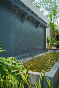 玛琅Se.nandung Living and Space的花园内带喷泉的游泳池