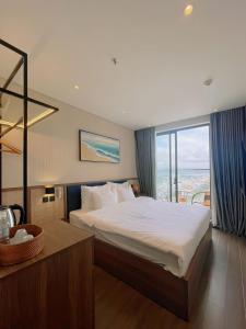 绥和市Apec Phú Yên SeaView Condotel的一间卧室设有一张大床和一个大窗户