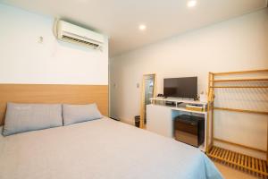 首尔Parkavenue Guesthouse的一间卧室配有一张床和电视