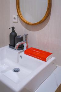 玛琅Se.nandung Living and Space的红色的书,坐在浴室水槽上