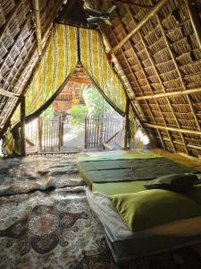 DaanbantayanTribal Huts Community的一间带两张床的卧室和茅草屋顶