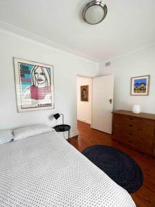 悉尼Stylish & Sunlit Bellevue Hill的一间卧室配有一张床和一个挂在墙上的梳妆台。