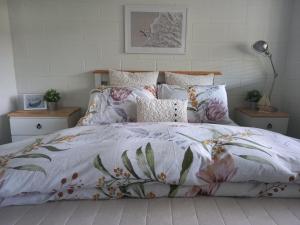 旺阿马塔Anchor watch的一张带花卉棉被和枕头的床