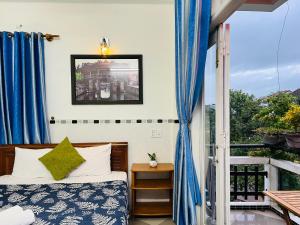 会安Phuc Bao Center Local Homestay - 3 mins walk to Old Town的一间卧室配有床和蓝色窗帘的窗户