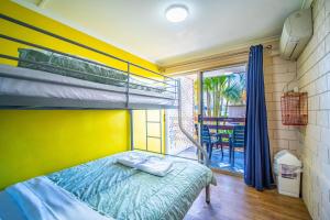 埃尔利海滩The Hostel, Airlie Beach的一间带双层床的卧室和一个阳台