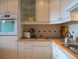 蒂涅Appartement Tignes, 2 pièces, 5 personnes - FR-1-449-137的厨房配有白色橱柜和水槽