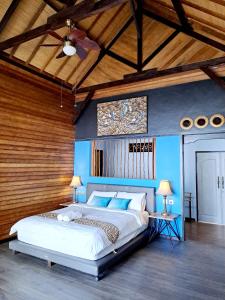 珀尼达岛Beach House Penida的一间卧室配有一张带蓝色墙壁的大床