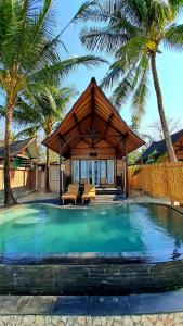 珀尼达岛Beach House Penida的一座带游泳池和棕榈树的房子