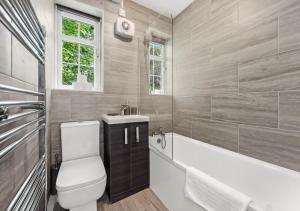 伦敦Radiant Serenity: 2BR Flat Sleeps 5 -Warm Ambiance的浴室配有卫生间、浴缸和水槽。