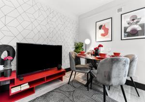 伦敦Radiant Serenity: 2BR Flat Sleeps 5 -Warm Ambiance的客厅配有电视和桌椅