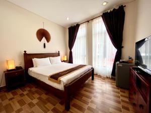 芹苴南波精品酒店的一间卧室配有一张床和一台平面电视