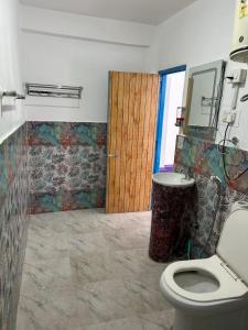 马拉里Tiny Spot Hostel的一间带卫生间和木门的浴室