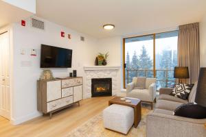 惠斯勒600 SQFT 1 Bed 1 Bath Mountain View Suite at Cascade Lodge in Whistler Village Sleeps 4的客厅设有壁炉和电视。