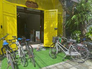 岘港Lu Peaceful Homestay的停在黄色建筑前面的一群自行车