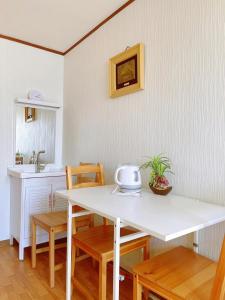 大阪Nippori Osaka Nishi-Tengachaya Guesthouse西天下茶屋アパートメント的厨房配有白色的桌椅和水槽