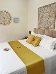 SempidiKandjeng Puri Kailas Canggu的一间卧室配有一张带黄色和白色枕头的大床